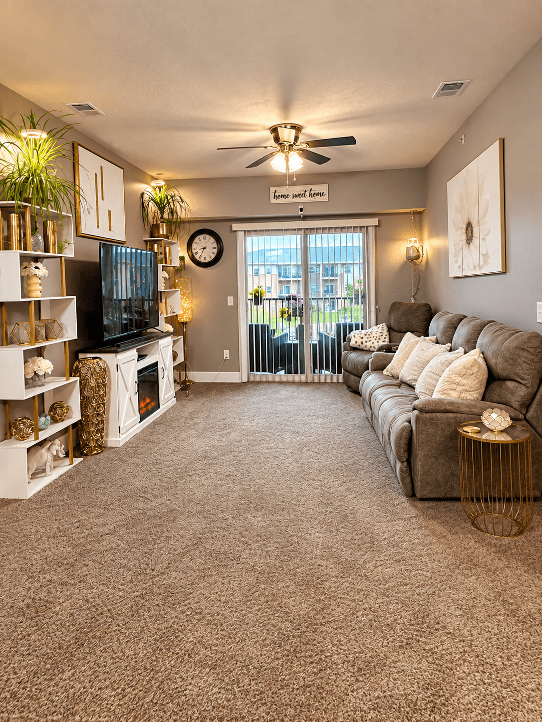 A living room with a grey carpet and a brown sofa.